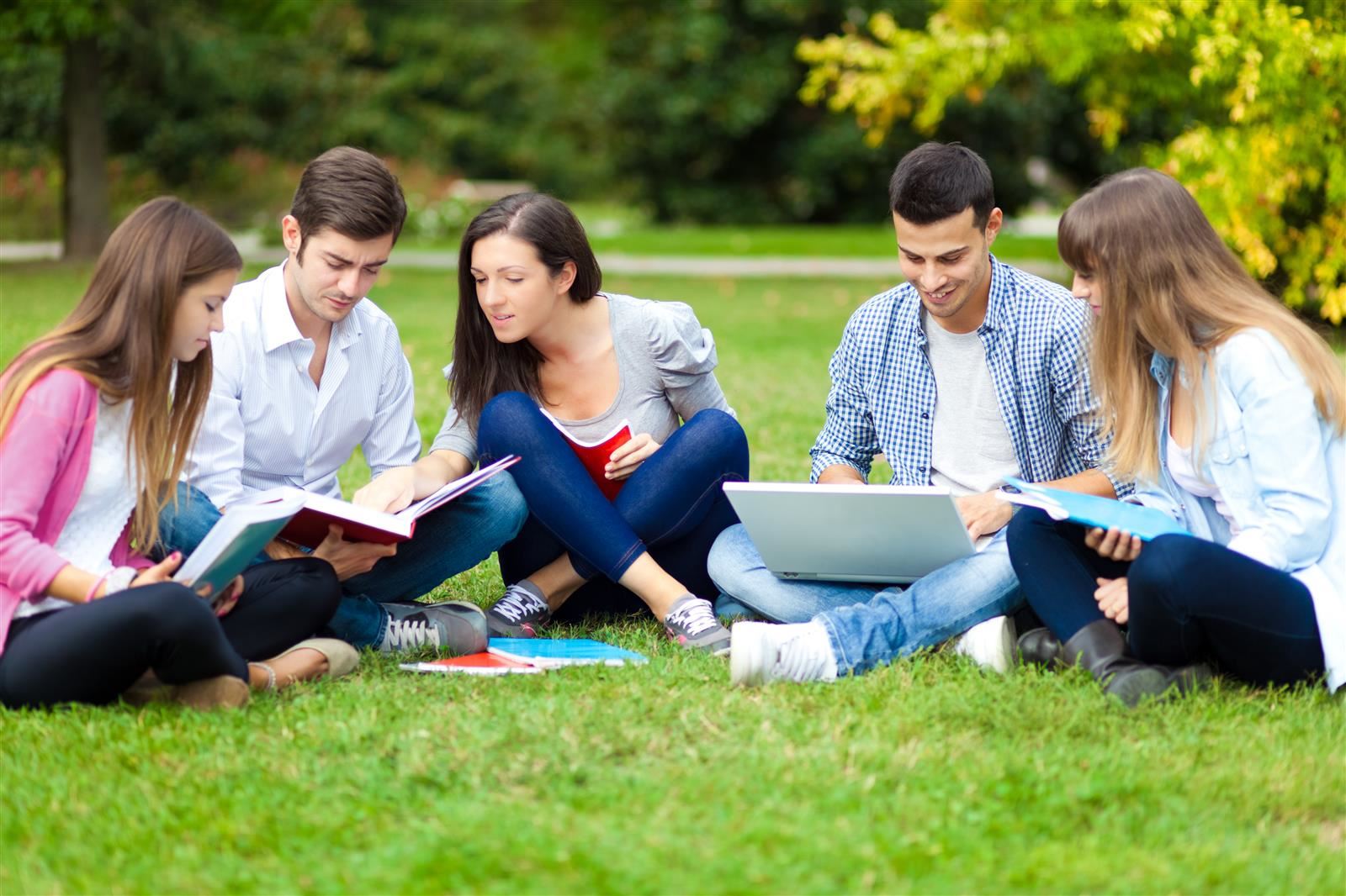  high school students on lawn with computers